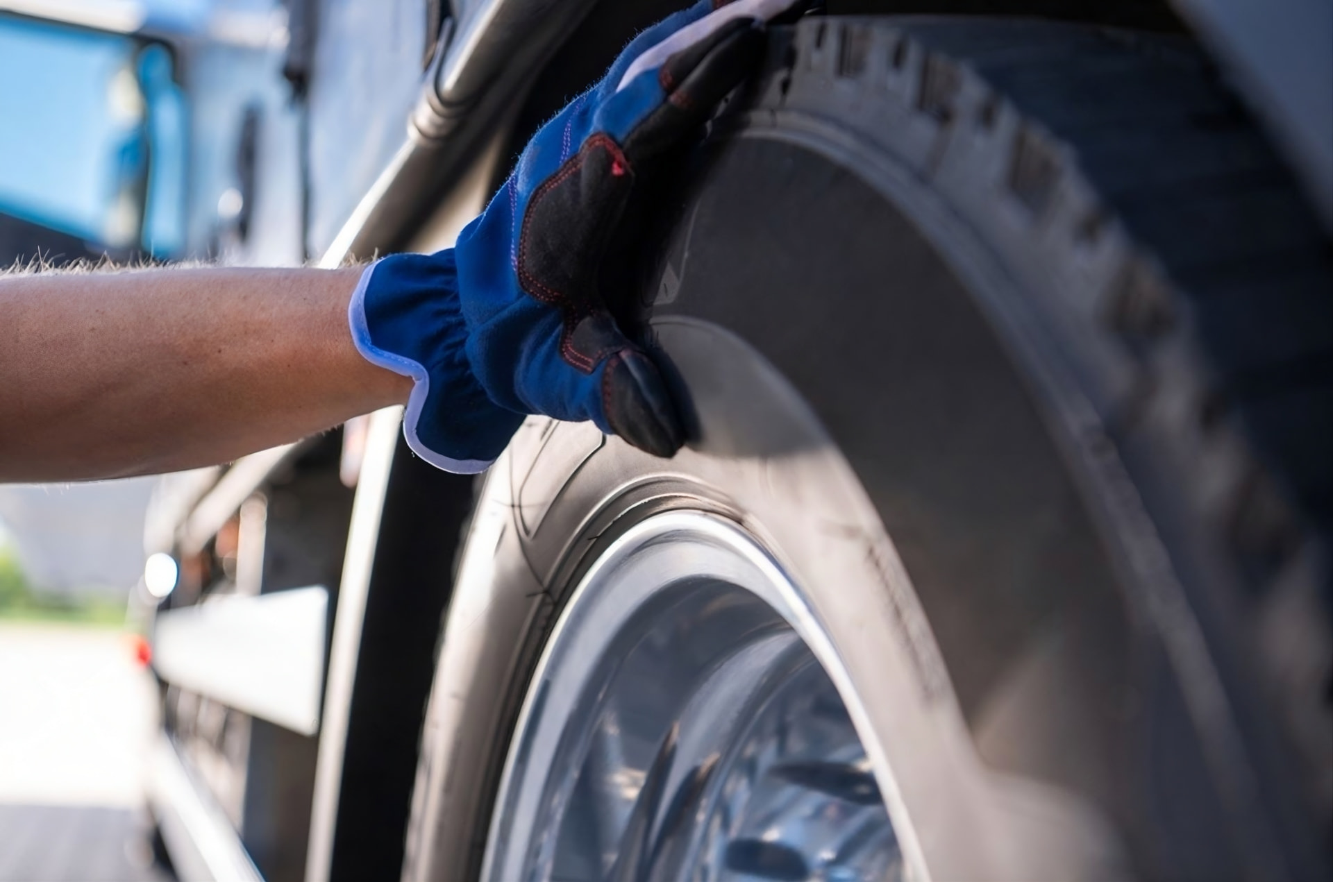 Gloved hand inspecting a truck tire during a pre-trip safety check